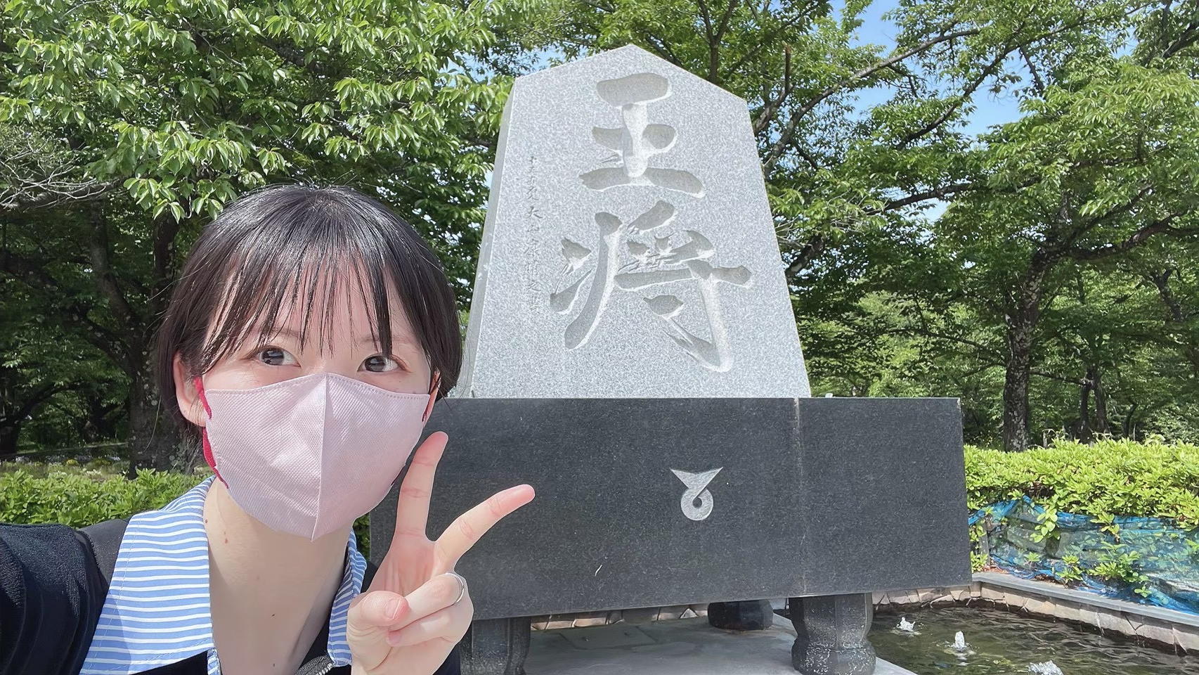 王将の石碑の前でピースをするなぎちゃん